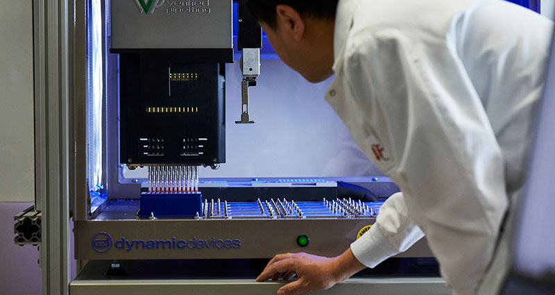 Man in lab coat using machine