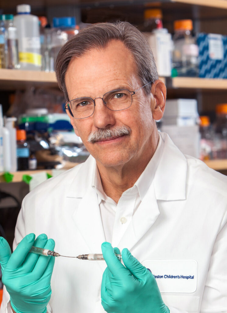 Timothy Springer in lab coat holding scientific tool..