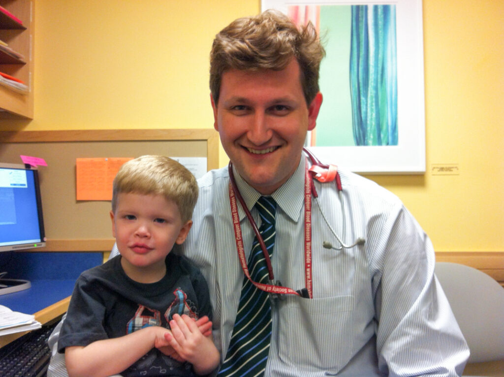 Doctor with his a patient, a smiling young boy.