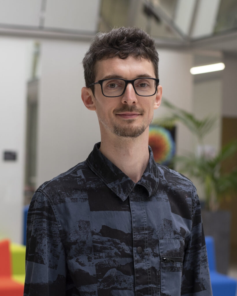 Man with glasses standing in office.