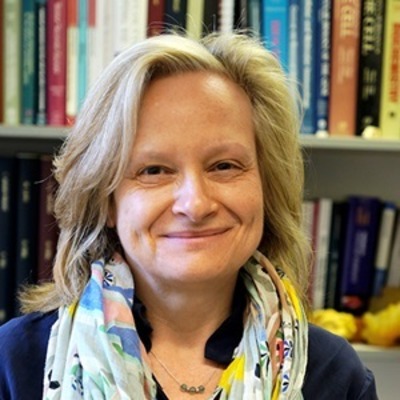 Headshot of woman smiling in front of bookshelves