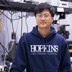 Man in sweatshirt standing in lab.