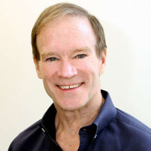 Rusty Williams smiling in front of a white background.