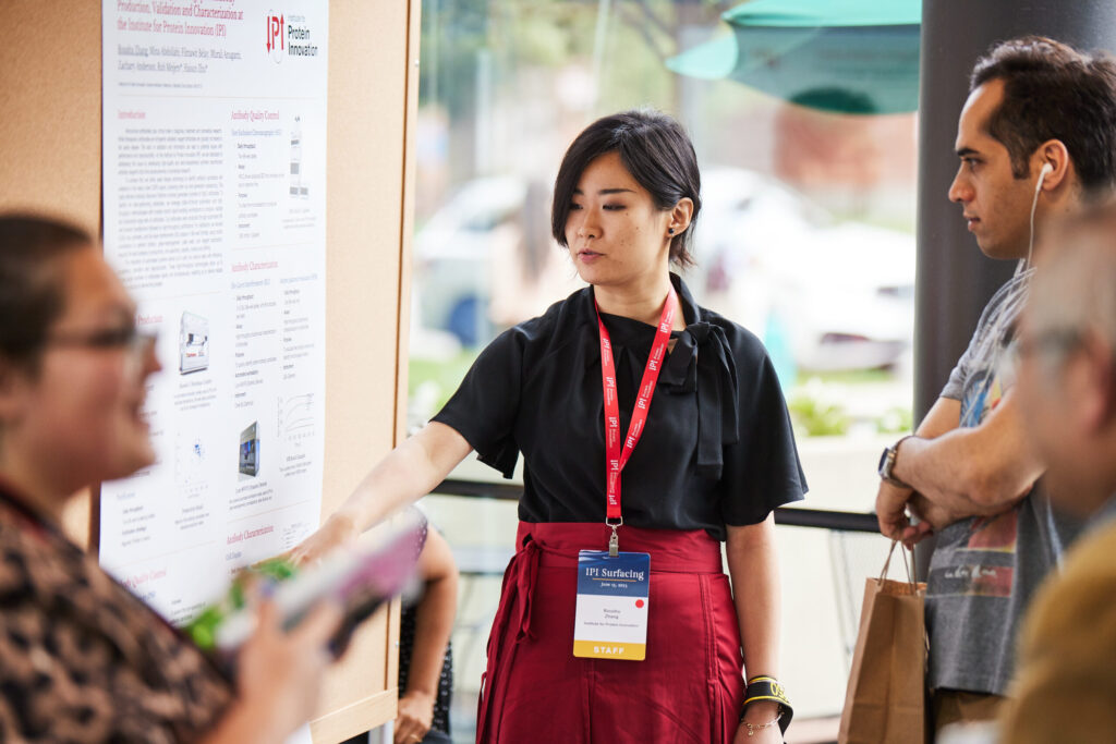 Woman points to figure on scientific poster.