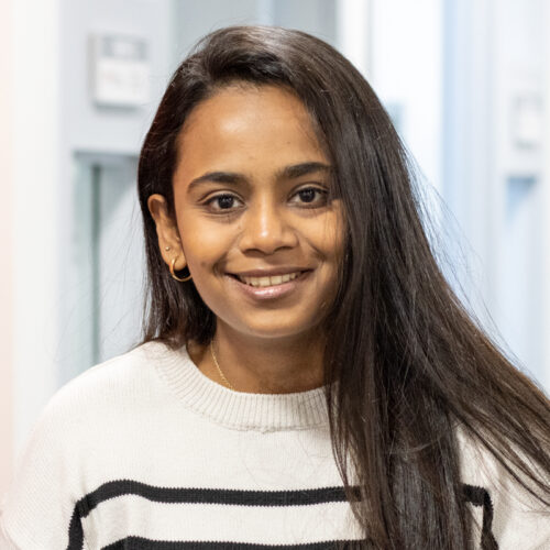 Woman smiles for headshot in an office.