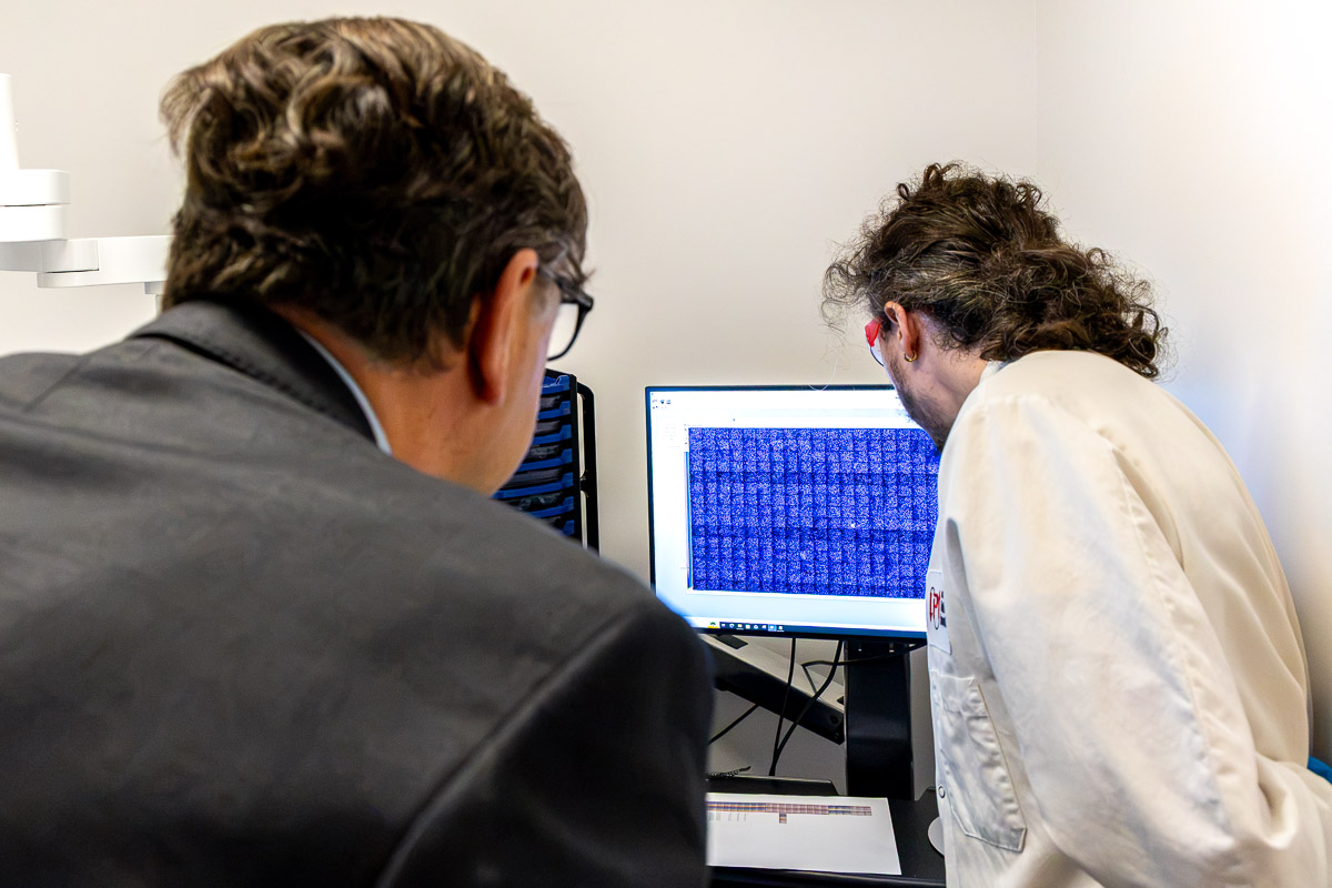 Two people review lab results on computer screen.
