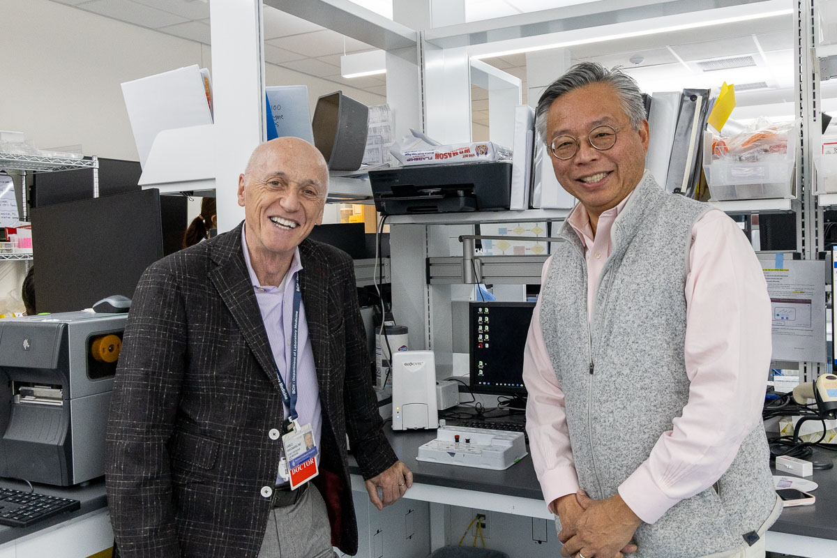 Two men stand in lab.